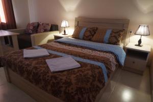 1 dormitorio con 1 cama con 2 toallas en Borjomi Cottages en Borjomi