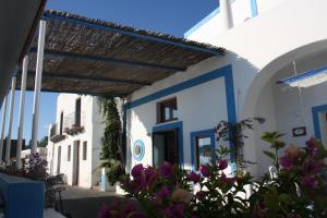 a blue and white building with flowers in front of it at Da Nino sul mare in Filicudi