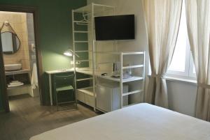 a bedroom with a white shelving unit with a television at B&B Quattordici in Agropoli