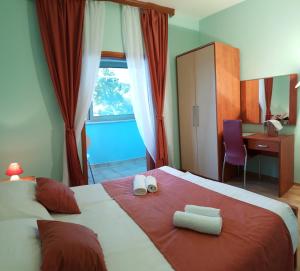 a bedroom with a large bed with two towels on it at Guesthouse Pomena in Pomena