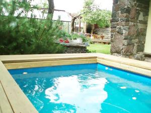 a swimming pool with blue water in a yard at Villa Lille in Pärnu