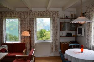 a living room with a table and two windows at Tunold Gård - Gamle huset in Mindresunde