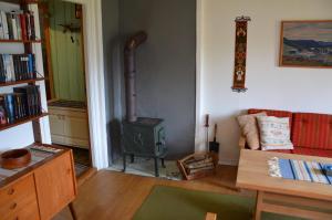 a living room with a stove and a couch at Tunold Gård - Gamle huset in Mindresunde