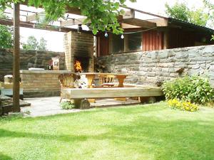 a wooden bench in a yard with a stone wall at Villa Lille in Pärnu