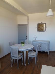 ein Esszimmer mit einem weißen Tisch und Stühlen in der Unterkunft Entre Estuaire et Citadelle in Blaye