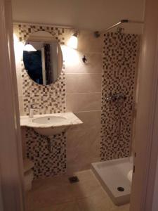 a bathroom with a sink and a mirror and a tub at Villa Jasmin Studios in Gouvia
