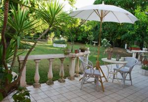 a table and chairs and an umbrella on a patio at Villa Jasmin Studios in Gouvia