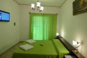 a bedroom with a green bed and a television at Departamento Centrico in Villa Carlos Paz