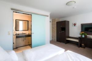 a bedroom with a large glass door leading to a bathroom at Hotel Landgasthof Birkenfelder Hof in Birkenfeld