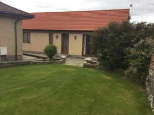 een huis met een groene tuin met een huis bij Langley Cottage with patio, spacious rooms - part of Langley Serviced Apartments several properties in Wick in Wick