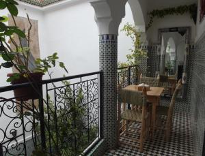 a balcony with a table and a mirror at Riad Sijane in Marrakesh