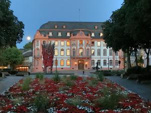 ein großes Gebäude mit einem Garten davor in der Unterkunft Osteiner Hof by The Apartment Suite in Mainz