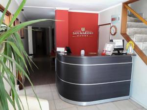ベナド・トゥエルトにあるHotel San Marinoの赤い壁のロビーのフロントデスク