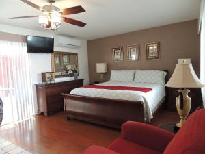 1 dormitorio con 1 cama y ventilador de techo en Casa Larrea Inn en Palm Desert