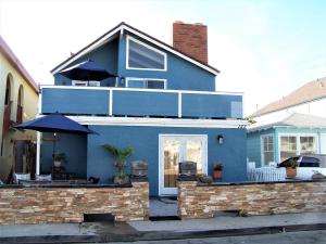 a blue house with an umbrella in front of it at Beach House in Newport Beach