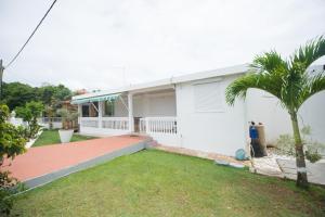 una casa blanca con una palmera en el patio en Locastudio - Grenadine, en Sainte-Anne