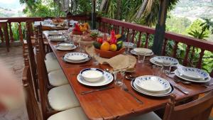 a long wooden table with plates and bowls of fruit at Hacienda Gonzabal in Loja