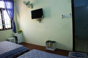 a bedroom with a bed and a tv on the wall at Hotel An Nhien in Buon Ma Thuot +34 photos
