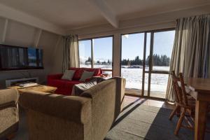 a living room with a red couch and a table at Arosa - Lake Tekapo in Lake Tekapo