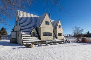 a house with a gambrel roof in the snow at Arosa - Lake Tekapo in Lake Tekapo