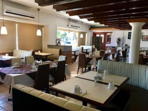 un restaurant avec des tables et des chaises ainsi qu'une salle à manger dans l'établissement Hotel del Valle, à Culiacán