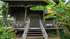 Un escalier mène à une maison avec terrasse couverte. dans l'établissement Sala Lodges, à Siem Reap