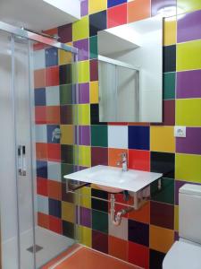 y baño colorido con lavabo y ducha. en Pensión San Fermín, en San Sebastián
