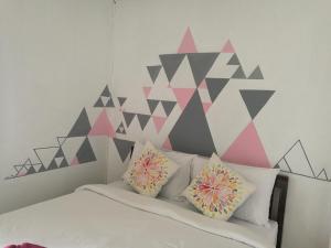a bedroom with a bed with a geometric wall at NT House in Chiang Rai