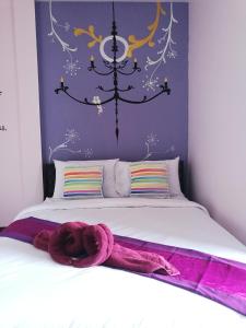 um quarto com uma cama com um lustre por cima em NT House em Chiang Rai