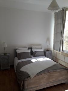 a white bedroom with a large bed with pillows at Entre Estuaire et Citadelle in Blaye