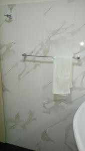 a bathroom with a glass shower with a toilet and a towel at Himo Guest Inn in Dehiwala