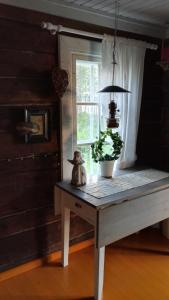 a table with a plant on it in a room with a window at Salen Saunamökki in Ranua