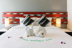 een slaapkamer met een bed met drie zwanendecoraties erop bij Sorin hotel in Surin