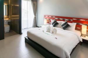- une chambre avec un grand lit blanc et une tête de lit rouge dans l'établissement Sorin hotel, à Surin