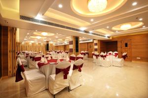 a banquet hall with white chairs and tables with red bows at Mint Hotel Premia Chandigarh, Zirakpur in Chandīgarh