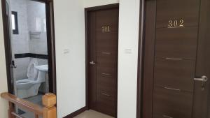 a bathroom with two wooden doors and a toilet at Fishmoon homestay in Magong