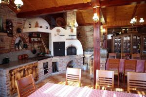 a kitchen with a brick fireplace and a table and chairs at Vándor Vigadó in Zalaegerszeg