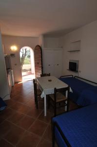 a living room with a table and a room with a kitchen at Appartamenti I Lauri in Porto Azzurro