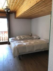 a bedroom with two beds and a wooden ceiling at Très spacieux chalet rénové été 2026 - 14 personnes coeur de village 150 m des pistes - in Montgenèvre