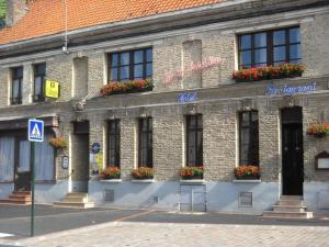 ein Backsteingebäude mit Blumenkästen an den Fenstern in der Unterkunft Le Saint Sébastien in Blendecques