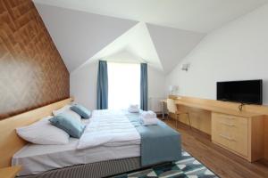 バラトンフレドにあるHoliday Exclusive Apartman Balatonfüredのベッドルーム1室(大型ベッド1台、薄型テレビ付)