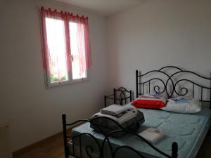 a bedroom with a bed with a bag on it at Maison Matha in La Cotinière