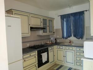 a kitchen with white cabinets and a stove top oven at Maison Matha in La Cotinière +9 photos