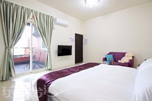 a bedroom with a bed and a window with a teddy bear at Shi Qing Homestay in Puli