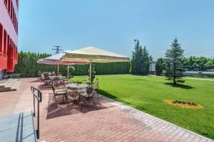 eine Terrasse mit Tischen, Stühlen und einer Liegewiese in der Unterkunft Hotel Chiirite in Plowdiw