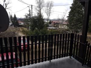 Ein schwarzer Zaun auf einer Veranda mit einem Auto in der Unterkunft Apartment Labud in Legrad