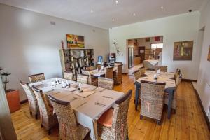 a restaurant with tables and chairs in a room at Summer Garden Guest House (The Palms) in Benoni