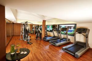 a gym with several treadmills and elliptical machines at The Gateway Hotel Beach Road, Calicut in Kozhikode