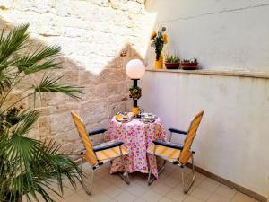 een tafel met een roze tafelkleed en twee stoelen bij B&B Aquila in Alberobello