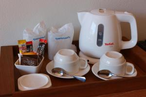 a wooden shelf with a coffee maker and cups and spoons at Crystal Lamai Hotel in Lamai